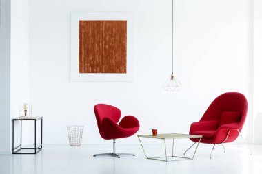 Modern daire iç masada koltuklar ile beyaz duvar üzerinde kırmızı boya. Gerçek fotoğraf