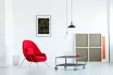 Minimalist oturma odası iç ile hareketli bir sehpa, kırmızı koltuk, lambalar ve resim sergisi