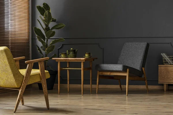 İki sandalye, dışkı, Çaydanlık ve bitki ile basit, karanlık retro oturma odası iç kavramı