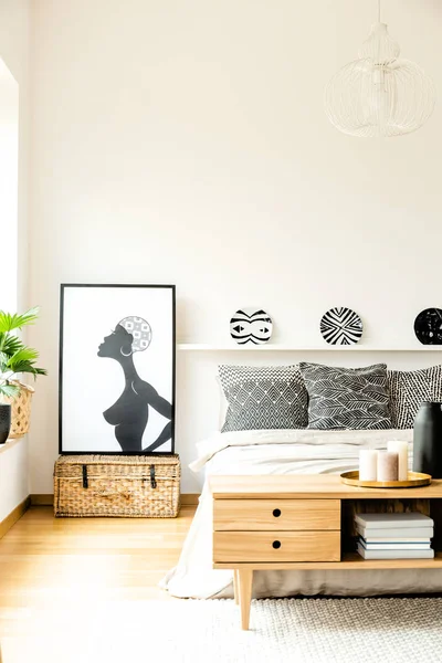 非洲海报旁边的床上有图案枕头下板在现代舒适的卧室内饰 — 图库照片
