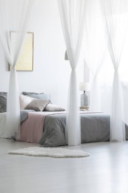 Parlak yatak odası iç duvar ve Çift Kişilik Yatak gri yatak ve birçok yastık ile cam lamba, altın poster ile