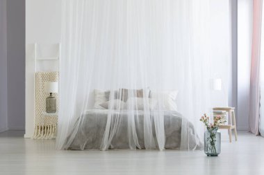 Çiçekler beyaz parlak yatak odası iç lamba ve merdiven ile gölgelik yatakta yanında. Gerçek fotoğraf