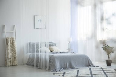 Gri örgü battaniye beyaz otel oda iç pencere perdeleri, desenli halı ve dekoratif merdiven ile gölgelik ile yatağın üstüne yerleştirilen