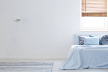 Beyaz lamba yatakta kopya alanı yanındaki mavi çarşaflı yatak odası iç. Dolabının bir yer ile gerçek fotoğraf