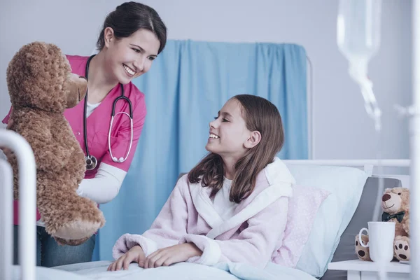 Médico Sonriente Uniforme Rosa Dando Peluche Niño Feliz Enfermo Centro — Foto de Stock