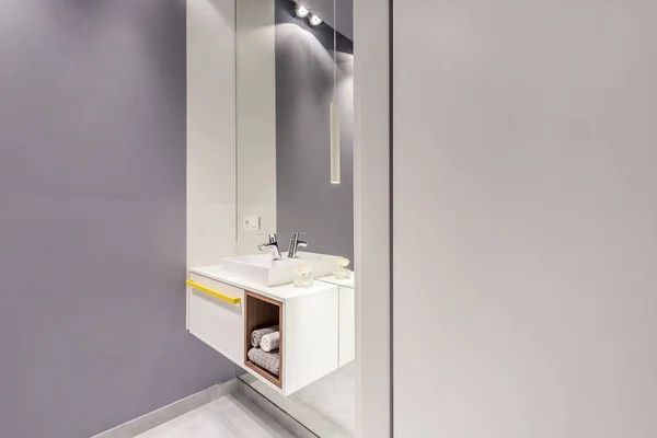 大きな鏡とタオルとあなたのポスターのための空の壁と灰色のバスルームのインテリアのシンク ホワイト食器棚の本物の写真 — ストック写真