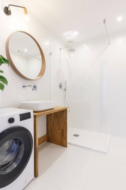 Beyaz modern banyo iç çamaşır makinesi ve bir ayna. Gerçek fotoğraf