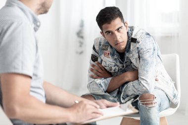 Kızgın genç adam bir psikolog bir rehabilitasyon merkezinde konuşma uyuşturucu bağımlılığı ile