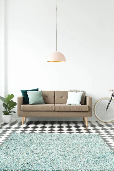 Beyaz oturma odası iç kahverengi kanepe yastıkları ile pastel pembe lamba, Saksı bitki ile dama tahtası katta melanj halı