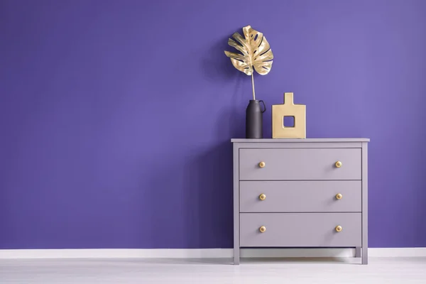 箱内有金色旋钮 花瓶和叶子设置在一个紫色的 空墙在室内内部 将您的产品 — 图库照片