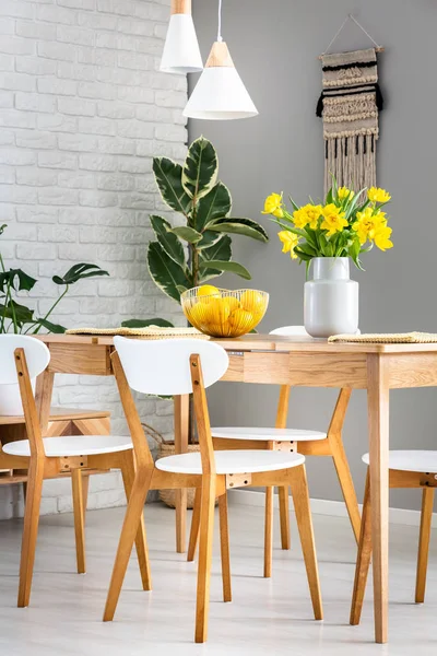 餐厅内有白色的椅子和灯 里面有水仙花和柠檬 在一张木桌上的碗里 真实照片 — 图库照片