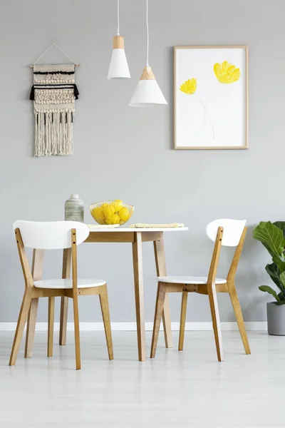 真正的照片 一个简单的 自然的餐厅室内有灯和海报 上面有黄色的花 桌子上有一张配有椅子的木桌 — 图库照片