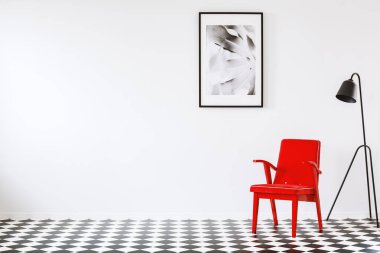Kırmızı koltuk boş iç poster ve kopya alanı olan dama tahtası katta siyah lamba yanında. Masanız için bir yer