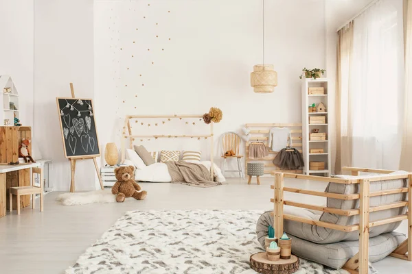 孩子的房间内部与一只泰迪熊在地板上 架子和木扶手椅 — 图库照片