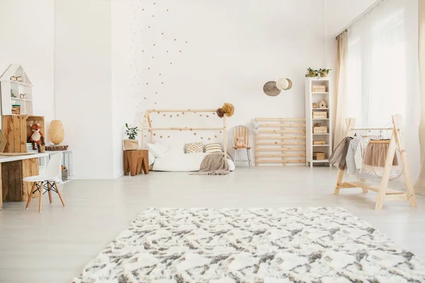 蓬松的地毯在白色孩子卧室内部与房子形状的床 窗口与窗帘 架子与箱子和小木衣架 — 图库照片