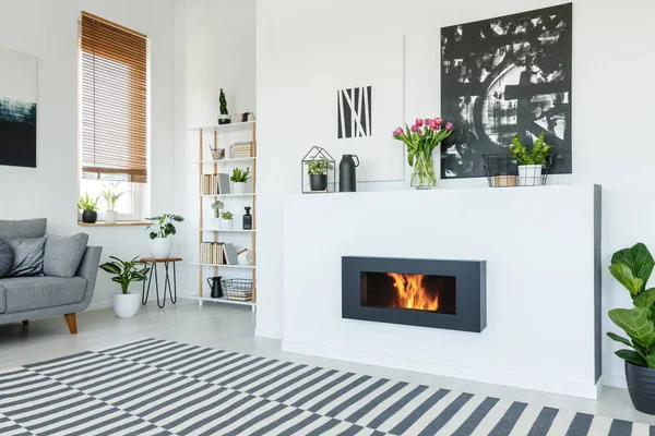 模様のカーペットとグレーのソファーが白のリビング ルームのインテリアに暖炉の上の黒塗装 実際の写真 — ストック写真