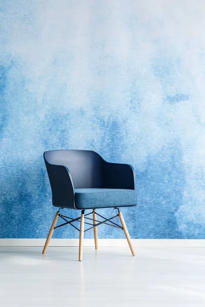 単一のモダンなネイビー ブルーの椅子オフィス室内で空の青と白のオンブル壁に立っています 領域をコピーします 実際の写真 — ストック写真