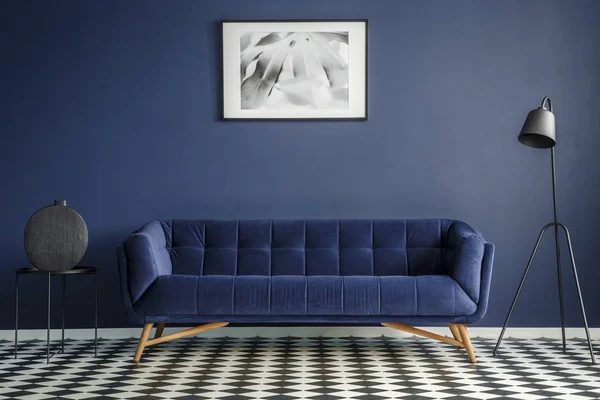 途中で快適な豪華なソファとネイビー ブルーの部屋インテリア黒ランプとサイド テーブル装飾チェス盤床の上に立って 壁に画像をフレームしました 実際の写真 — ストック写真