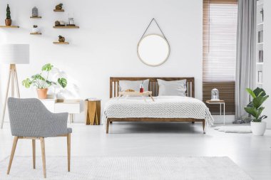 Gri, modern koltuk, kahvaltı tepsisi bir çift kişilik yatak ve bir daire basit, şık oda iç beyaz duvarlı ahşap mobilya