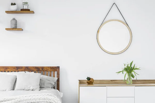 北欧スタイル ドレッサー 植物と木製の棚と花瓶 白い寝室のインテリアでラウンド ミラー チューリップ — ストック写真