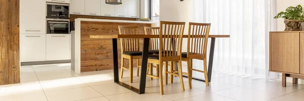 本物の写真の つの木製のダイニング テーブルの椅子オープン スペース キッチン インテリア白い棚 つのオーブンや木製カウンター トップに立って — ストック写真