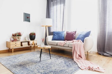 Heathers rustik dolap ve Divan Renkli minderler ile aydınlık oturma odası iç desenli halı üzerinde yuvarlak masa