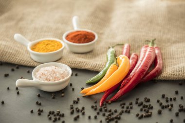 Pul biber, tuz, zerdeçal tozu ve karabiber etrafında mayınları bir masada kırmızı biber tozu