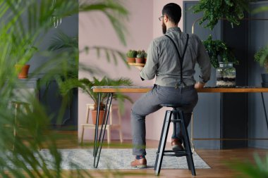 Bahçıvan holding succulents bitkiler ile şık iç ahşap masa