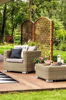 Yastıklar ve güzel bir yeşil bahçesinde bir terasta masa rattan koltuk