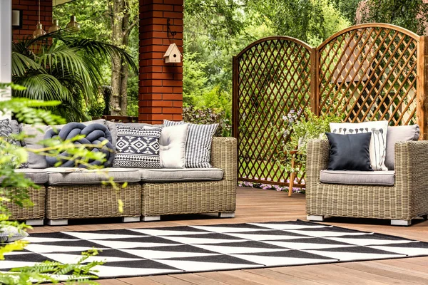 Geometrik halı yastık ile bahçe mobilyaları ile ahşap verandada. Gerçek fotoğraf