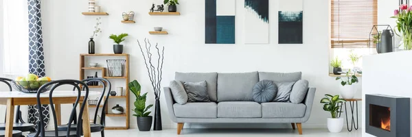现代灰色沙发上的舒适枕头在白色 自然生活和饭厅内部与木制家具和植物 — 图库照片