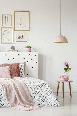 Ahşap sehpa ve sakin yatak odası iç beyaz duvarlı bir kolye lamba pembe, eski moda telefon