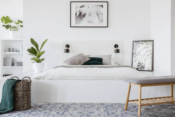 真正的照片 一张特大床站在白色的卧室内部与植物旁边 海报上面和货架背景 — 图库照片