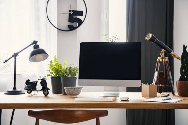 Ahşap modern freelancer masasında lambası ve masaüstü bilgisayarda saati ile iç. Gerçek fotoğraf