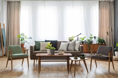 Ahşap masa koltuklar parlak daire iç kanepe ile arasında çiçekli. Gerçek fotoğraf