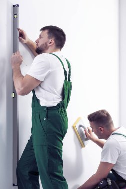 Ev yenileme ekibi beyaz duvar remodeling için hazırlanıyor