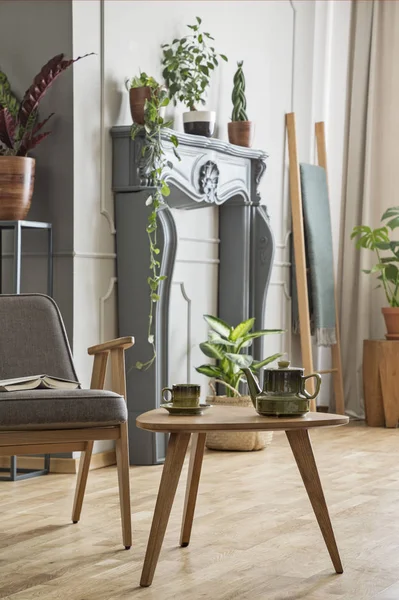 Ahşap masa retro oturma odası iç bitkiler ile gri tekli yanında. Gerçek fotoğraf