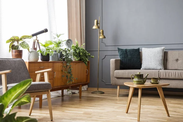 Ahşap masa vintage oturma odası iç kanepe ve koltuk arasında kabine ile. Gerçek fotoğraf