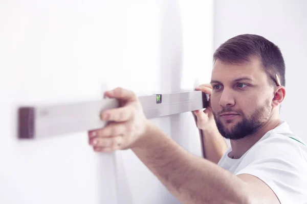 Handyman Com Nível Bolha Preparando Parede Branca Para Remodelação — Fotografia de Stock