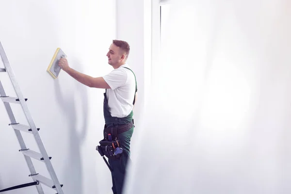 Smiling Handyman Cleaning White Wall Painting While Renovating Interior — Stock Photo, Image