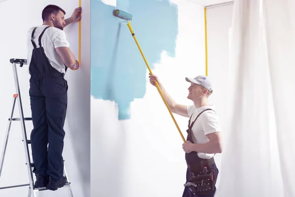 Man Met Roller Schilderij Witte Muur Blauwe Terwijl Afwerking Interieur — Stockfoto