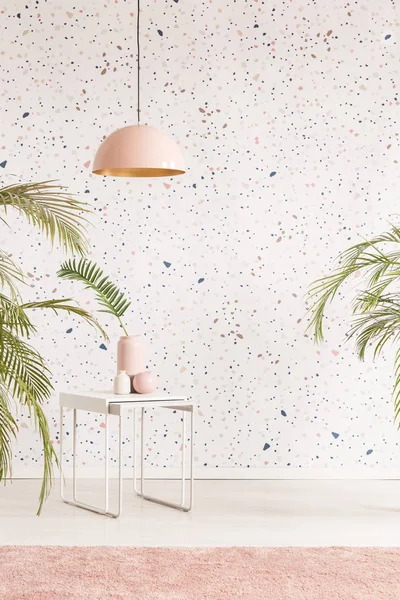 Pembe lamba beyaz masa oturma odası iç üretim tesisi ile desenli duvar kağıdı karşı yukarıda. Sandalye için bir yer ile gerçek fotoğraf