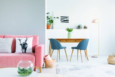 Yemek masasında görmek çiçek mavi sandalye ile parlak iç pembe kanepede yastık. Gerçek fotoğraf