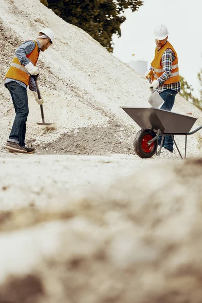 Lage Hoek Van Werknemers Met Schoppen Zand Ingebruikneming Een Kruiwagen — Stockfoto