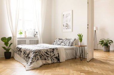 Poster bed parlak yatak odası iç penceresi ve bitki desenli yastıkları ile yukarıda. Gerçek fotoğraf