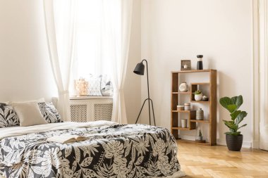 Bir çift kişilik yatak ile bir açık kitap, lamba, bookshelf süsleme ve bitki ile gerçek fotoğraf