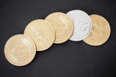 Siyah arka plan üzerine Bitcoin, Litecoin ve Ethereum altın sikkeler üzerinde üstten görünüm
