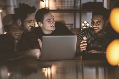 Dijital para satın alma ve hafta sonu boyunca laptop film izlerken mutlu arkadaşlar