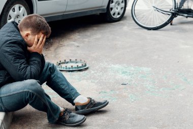 Onun araba ve kırık cam sokakta yanında bir kaldırımda oturan sürücü korkuttu