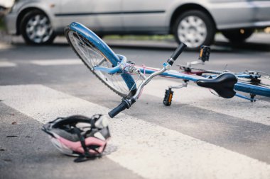 Bir araba ile şiddetli yağış sonrası bir yaya geçidi kask ve mavi çocuk bisiklet pink